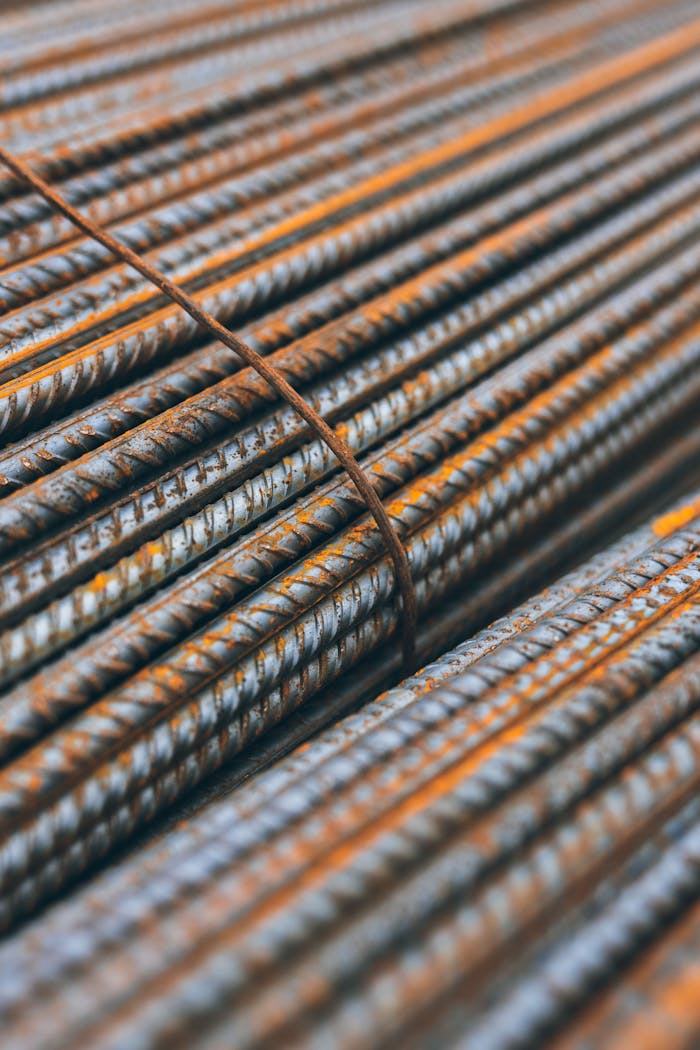 services-01 Detailed view of rusty steel rebars stacked in parallel pattern highlighting construction materials' texture.